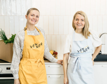 Vennerin perustajat Emilia Järvinen ja Tuulia Järvinen poseeraavat keittiössä essut päällä.